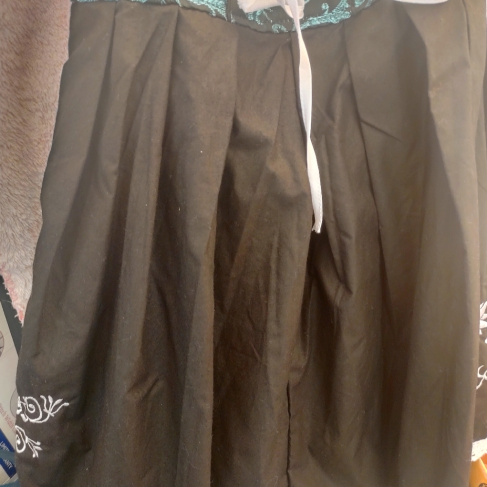 The green and black dress with embroidered flowers on the side and pockets.
